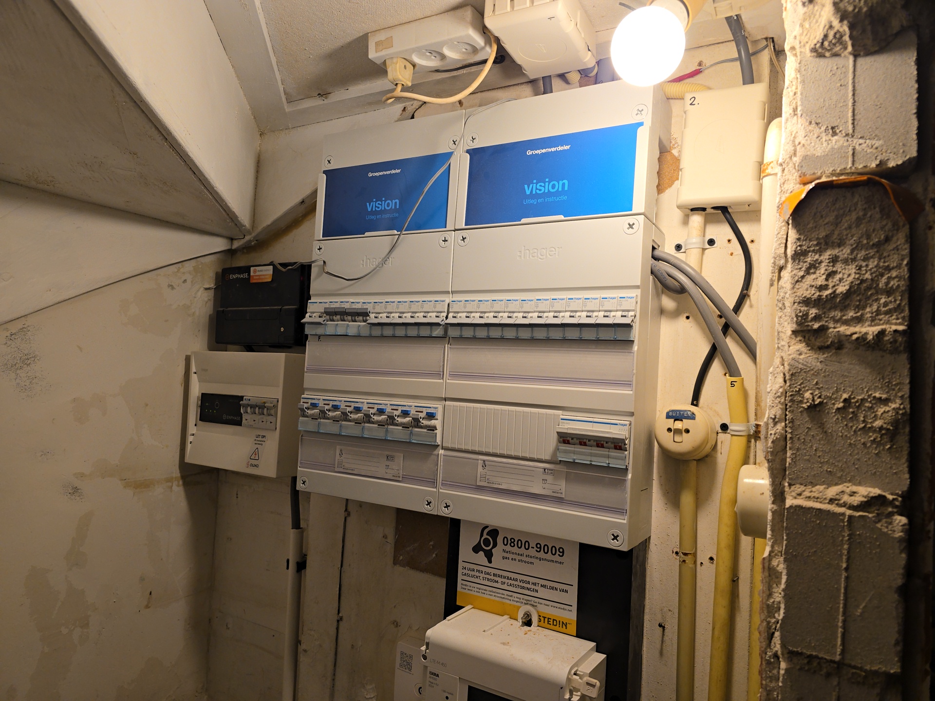 Meterkast met twee nieuwe Hager groepenverdelers naast de omvormer van de zonnepanelen